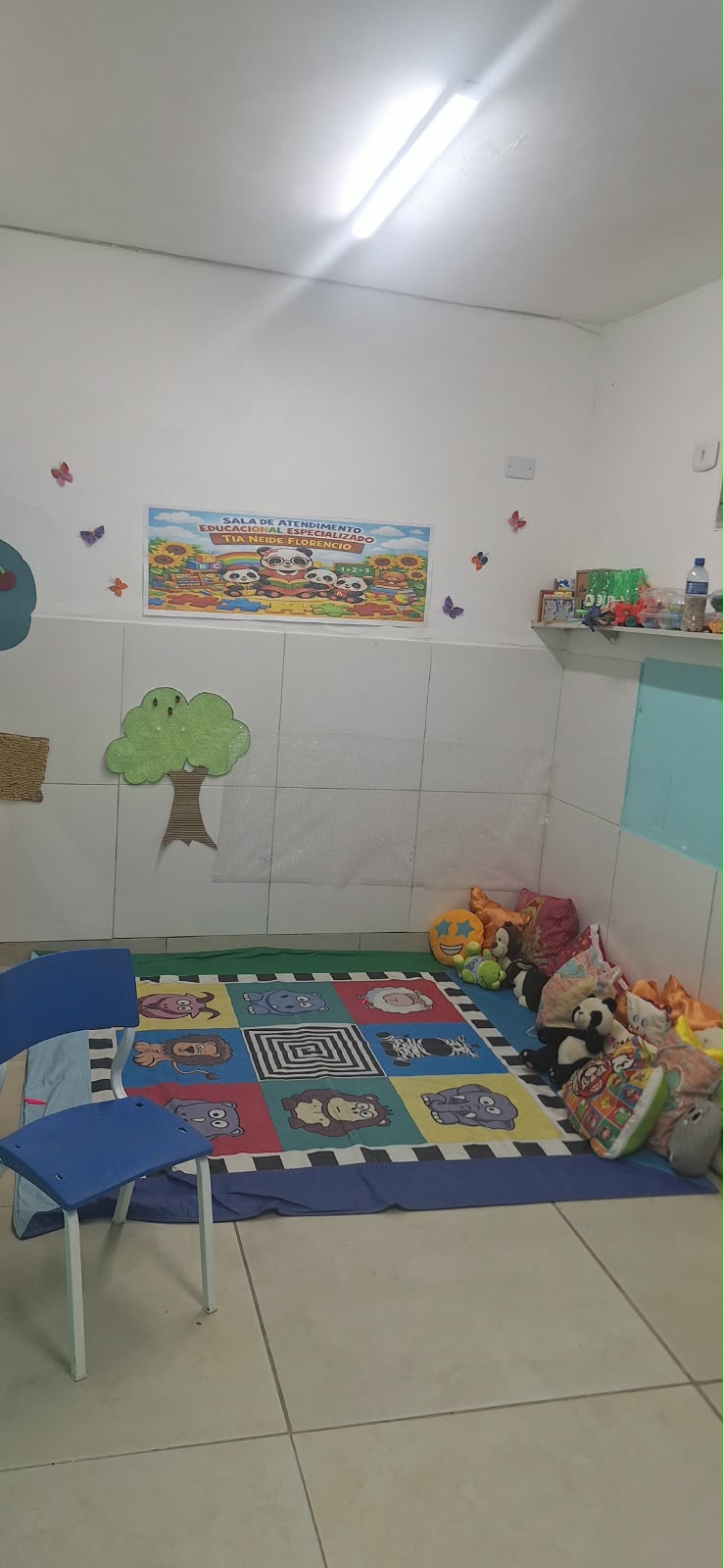 Sala de atendimento educacional especializado com tapete de atividades, brinquedos e materiais infantis.